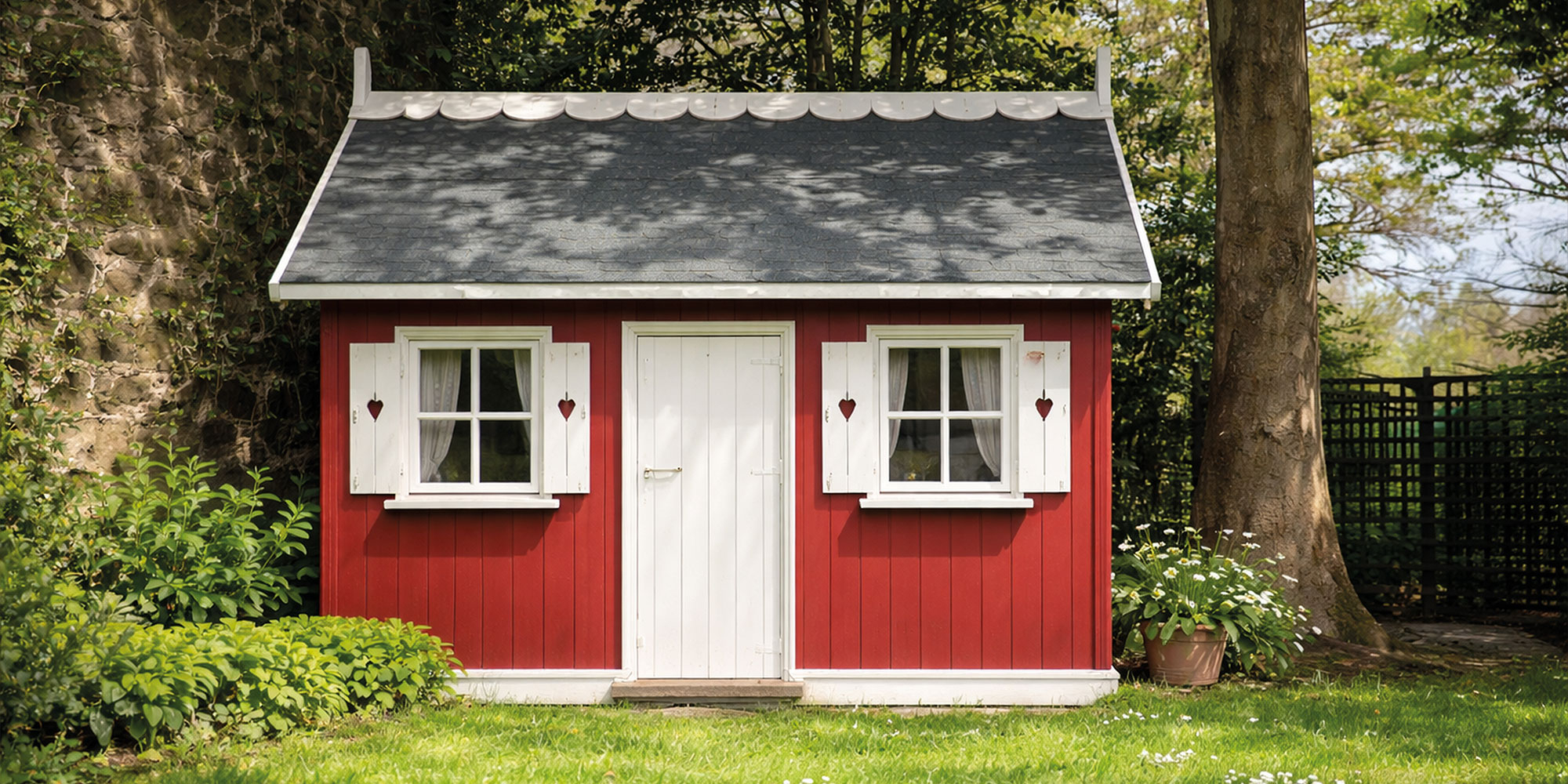 Kleines rotes Gartenhausauf einer Wiese