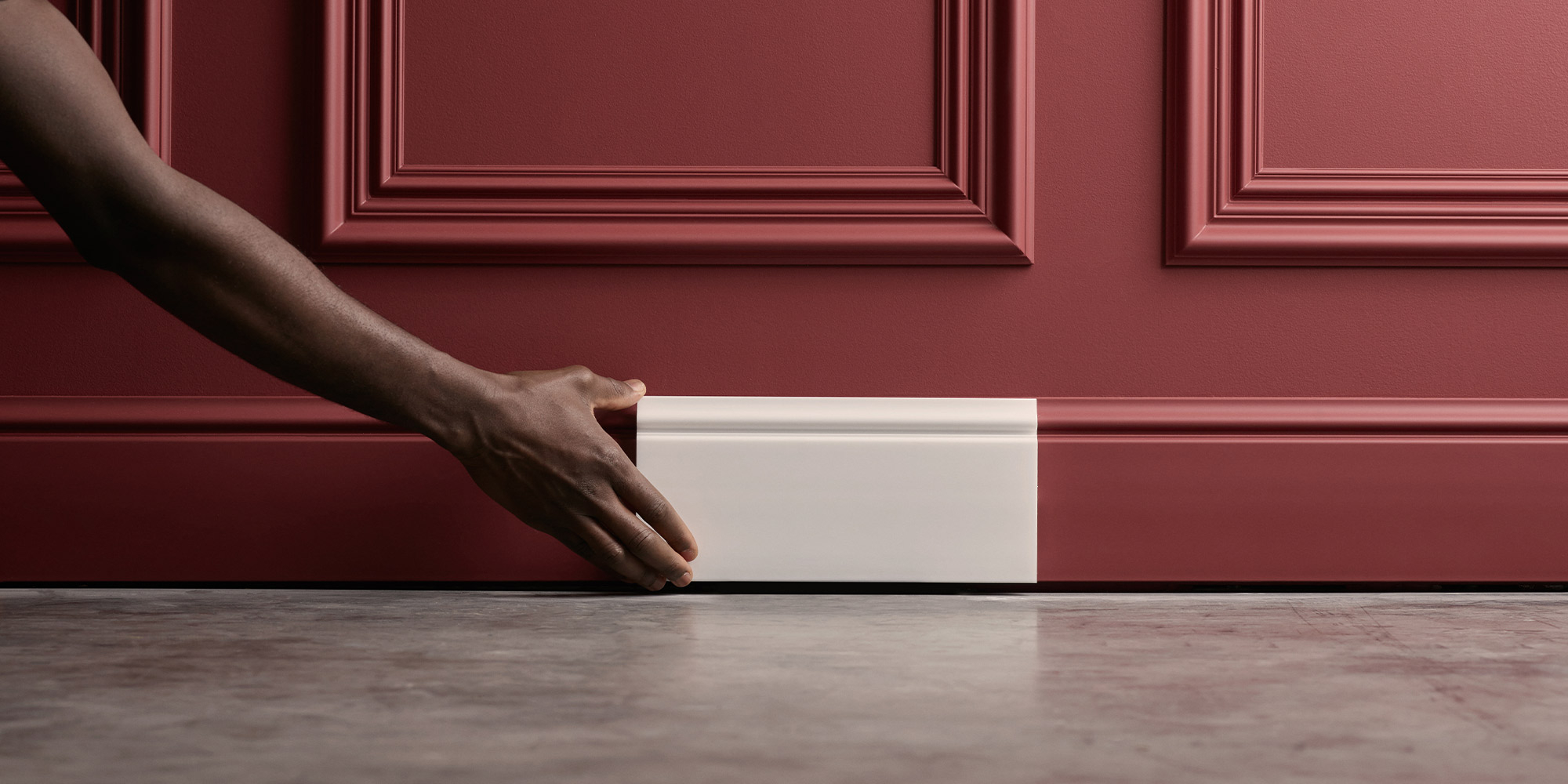 Ein Flur mit Wandfeldern aus Stuckleisten mit einer Fußleiste in Landhausoptik hervorheben.