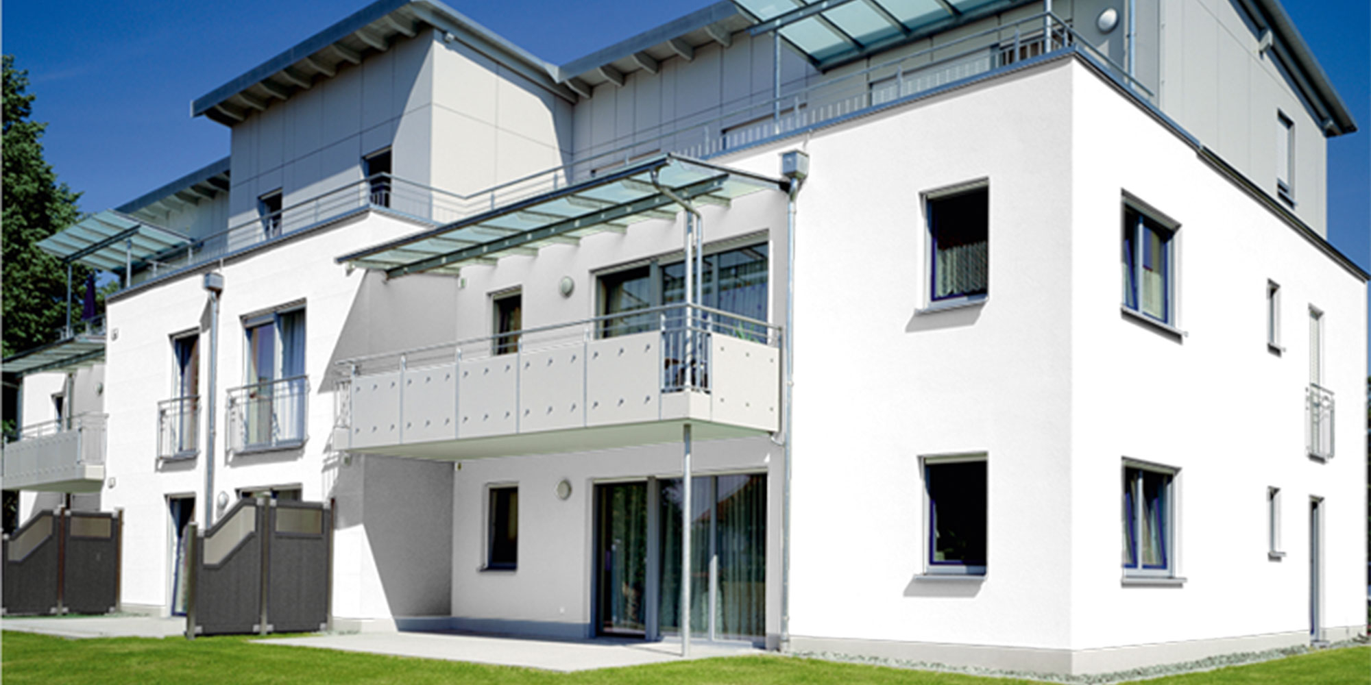 Modernes Wohnhaus mit weißer Putzfassade und Balkonen, Beispiel für Silikat Putz