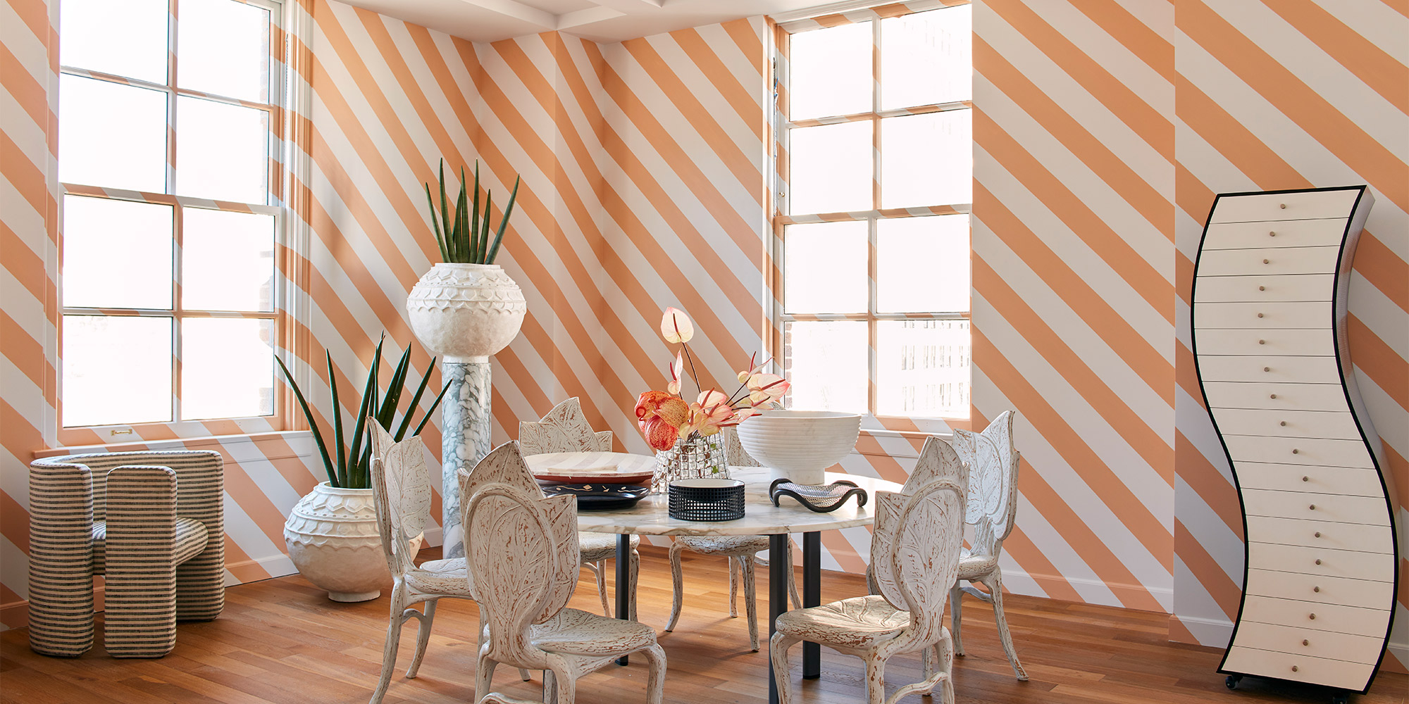 Heller Essbereich mit diagonal gestreiften Wänden als Beispiel für Wandfarbe in Innenräumen