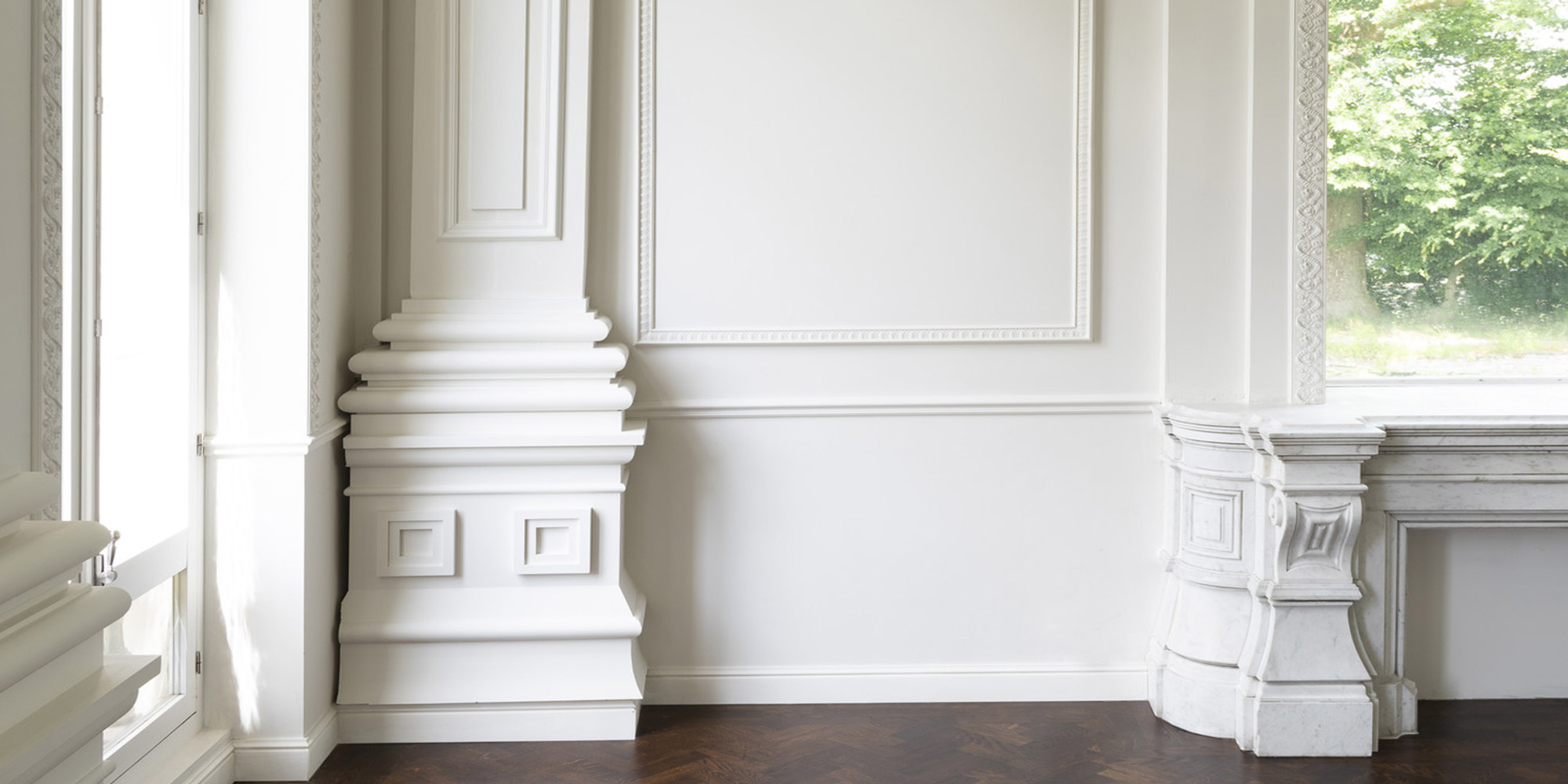 Eine klassische Stucksäule wirkt als optischer Hingucker in einem exklusiven Wohnzimmer.