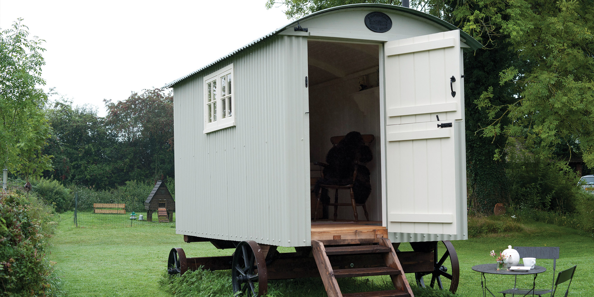 Gartenhaus mit gestrichenen Holzflaechen als Beispiel fuer Farben Lacke und Lasuren fuer Aussen