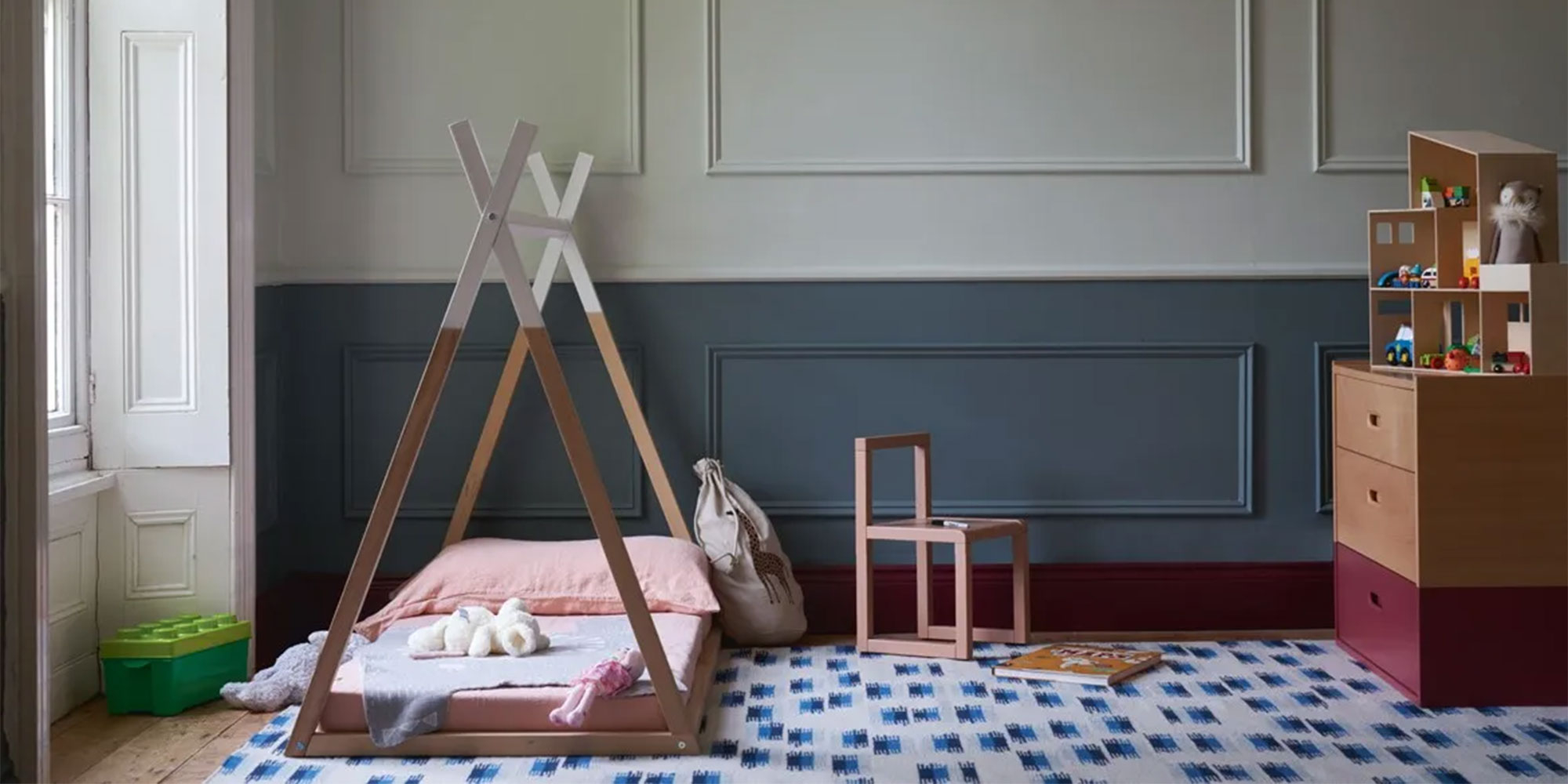 Spielzimmer mit zweifarbig gestrichener Wand, Tipi-Bett und Holzregal - Inspiration fuer kindersichere Farben und Lacke