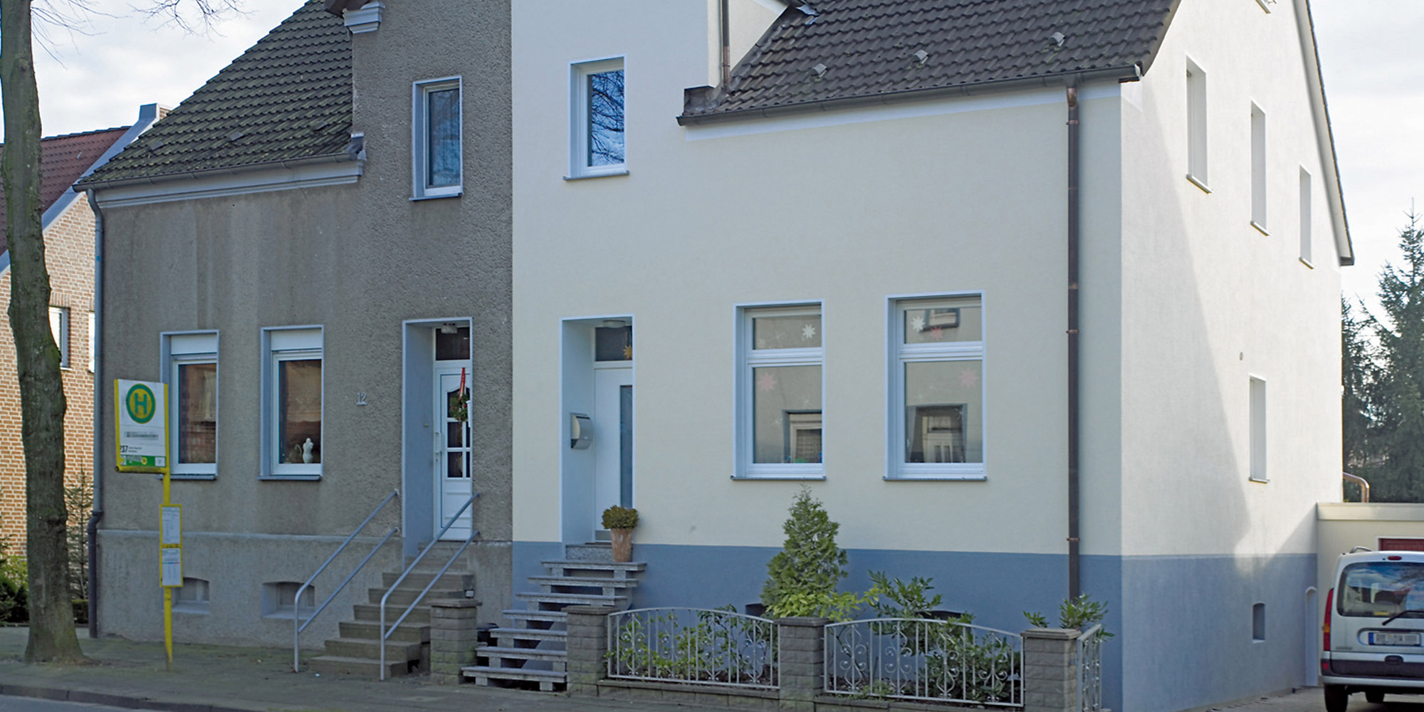 Wohnhaus mit heller Fassade und abgesetztem Sockel, Beispiel für gedämmte Außenwand