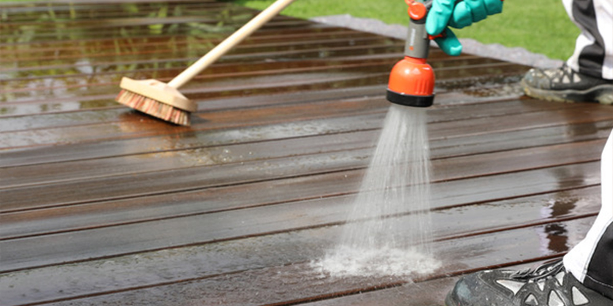 Reinigung einer Holzterrasse mit Wasserstrahl und Bürste