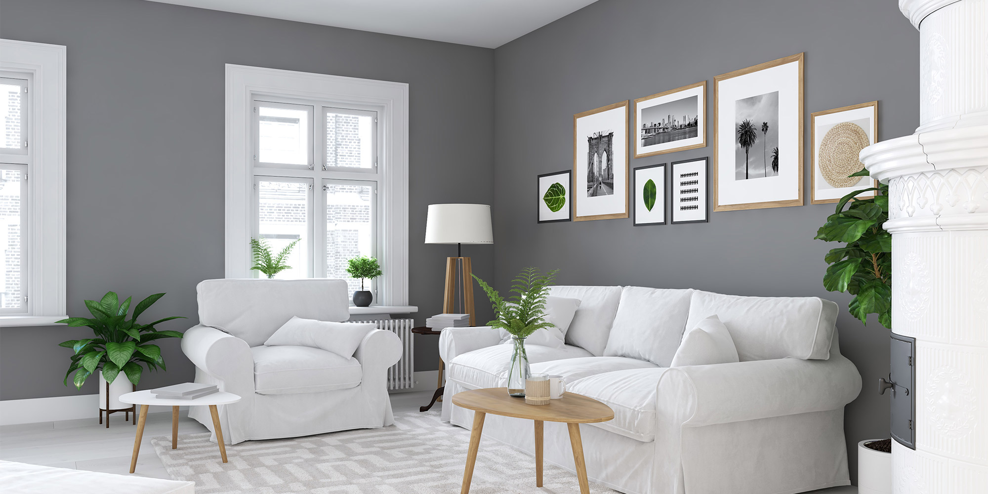 Helles Wohnzimmer mit grauer Wand, weißen Möbeln und grünen Pflanzen, stilvoll eingerichtet