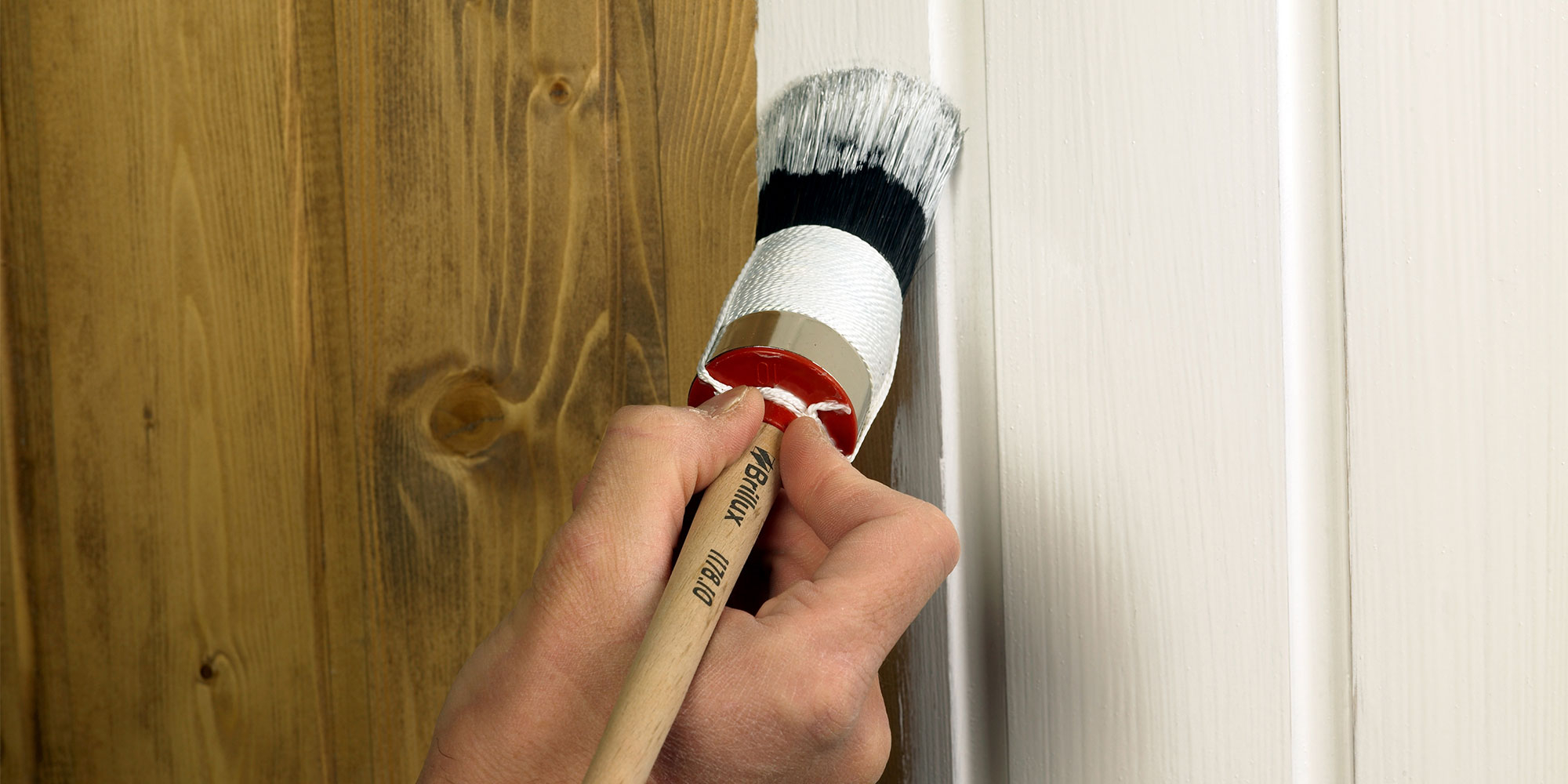 Hand streicht Holz mit Lack oder Lasur - gleichmaessiger Auftrag als Beispiel fuer FAQ