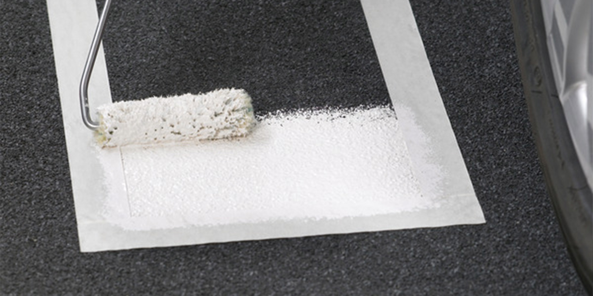 Beschichtung wird mit einer Rolle auf eine abgegrenzte Fläche aufgetragen, saubere Kanten