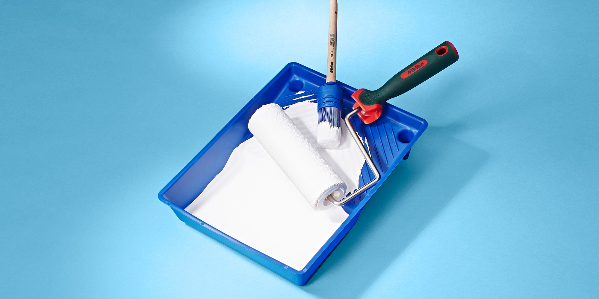 Farbwanne mit Farbrolle und Pinsel fuer gleichmaessiges Streichen