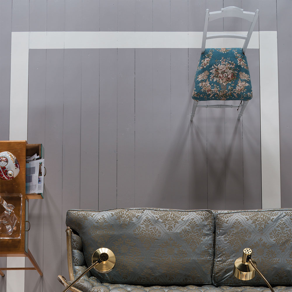 Grau gestrichener Holzboden mit weißer Rahmenlinie, Sofa und Stuhl - Beispiel für Bodenanstrich