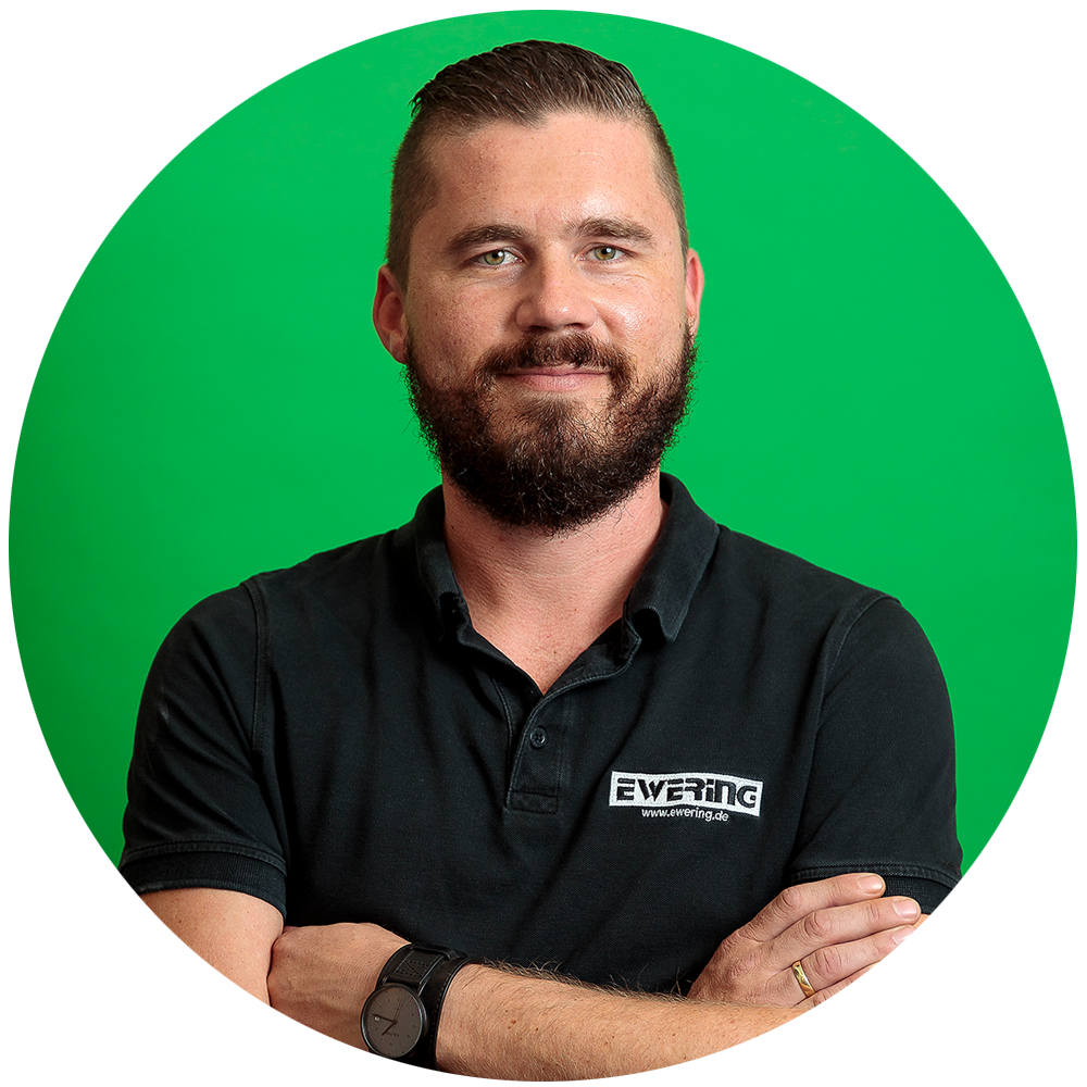 Porträt eines Mitarbeiters mit Bart vor grünem Hintergrund - Profitipp Wunschfarbton mischen