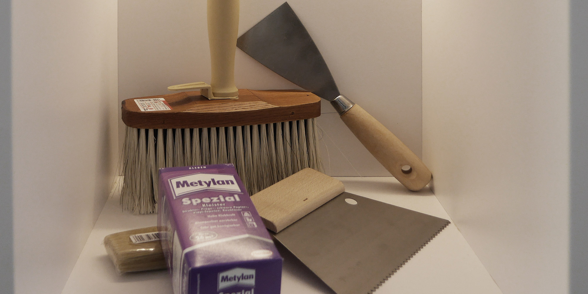 Tapezierwerkzeuge und Kleister fuer das Anbringen von Tapeten