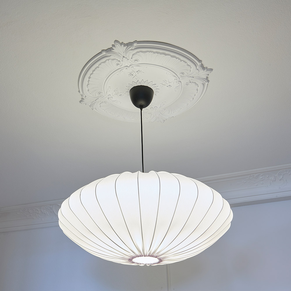 Eine klassische Stuckrosette setzt diese pendelleuchte in Szene.