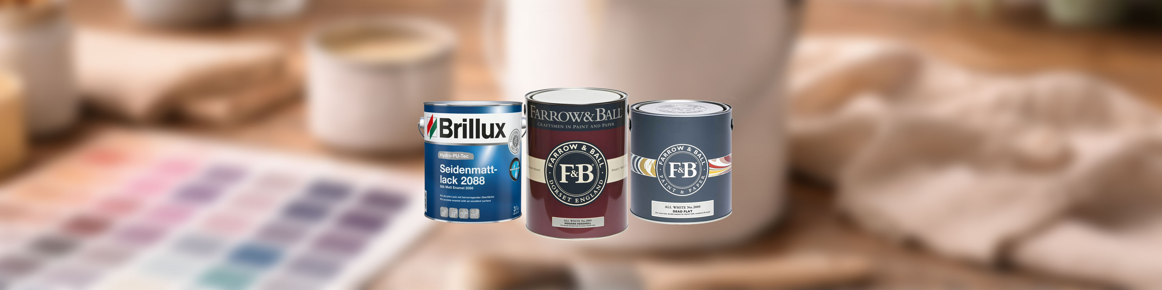 Drei Lackdosen für Möbelanstrich vor unscharfem Hintergrund, Brillux und Farrow and Ball