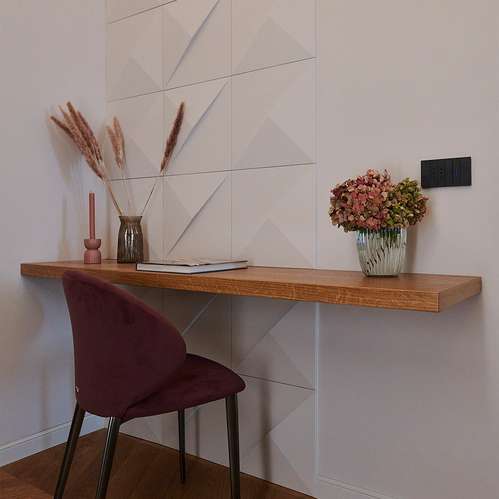 Grafische Wandpaneele gestalten eine Akzentwand hinter einem Holzboard.