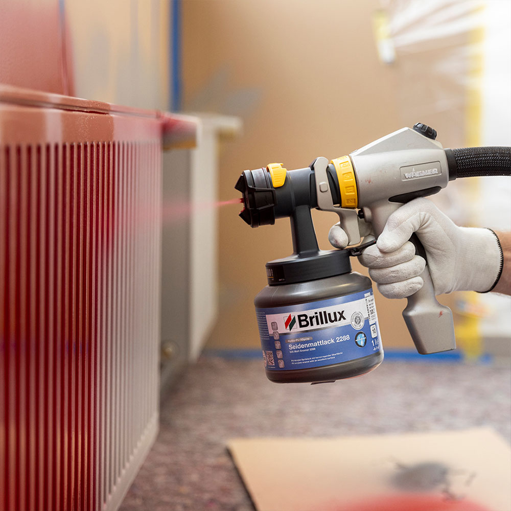 Heizkoerper wird mit Farbspruehgeraet gleichmaessig lackiert - Technik fuer schnelles Heizkoerper streichen