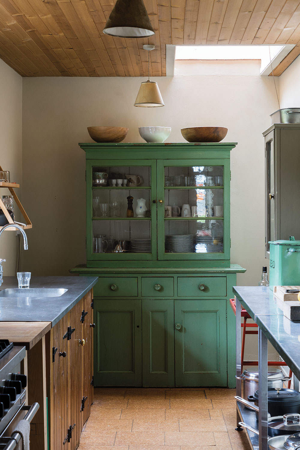 Kueche mit gruen gestrichenem Schrank und Geschirr hinter Glas - Beispiel fuer Kuechenmoebel streichen