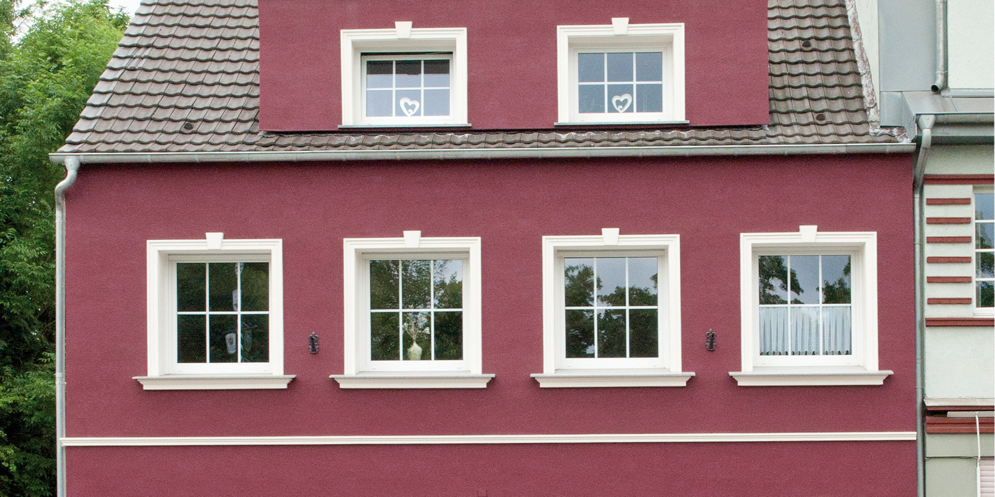 Kontrastreiche Fassadengestaltung mit weißen Fensterprofilen