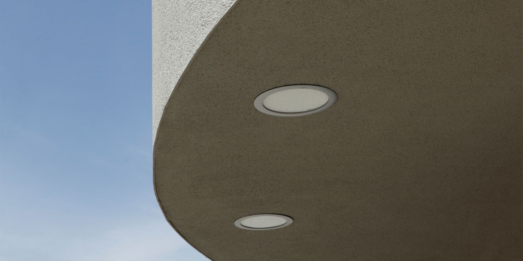 Unterseite eines auskragenden Balkons mit Einbauleuchten strukturierte Putzoberfläche