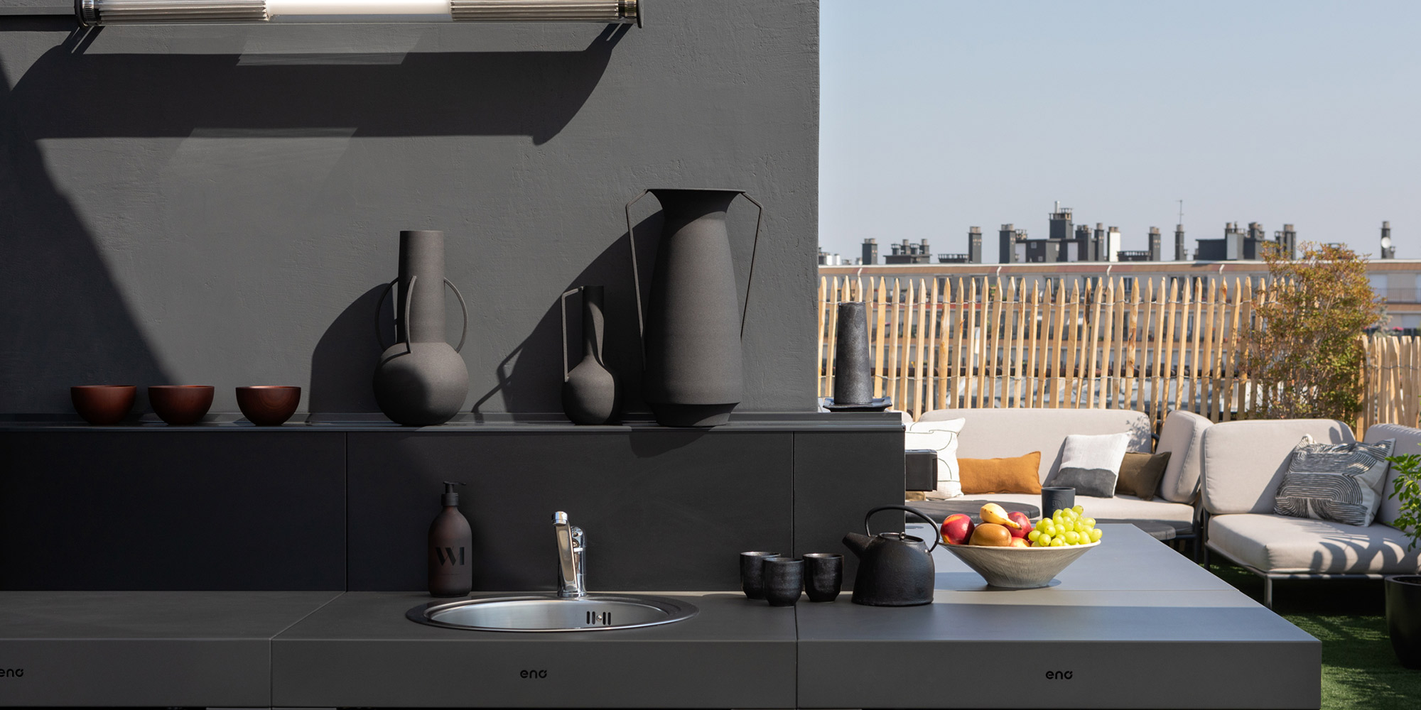 Moderne Aussenkueche mit dunklen Oberflaechen als Beispiel fuer Stein und Beton