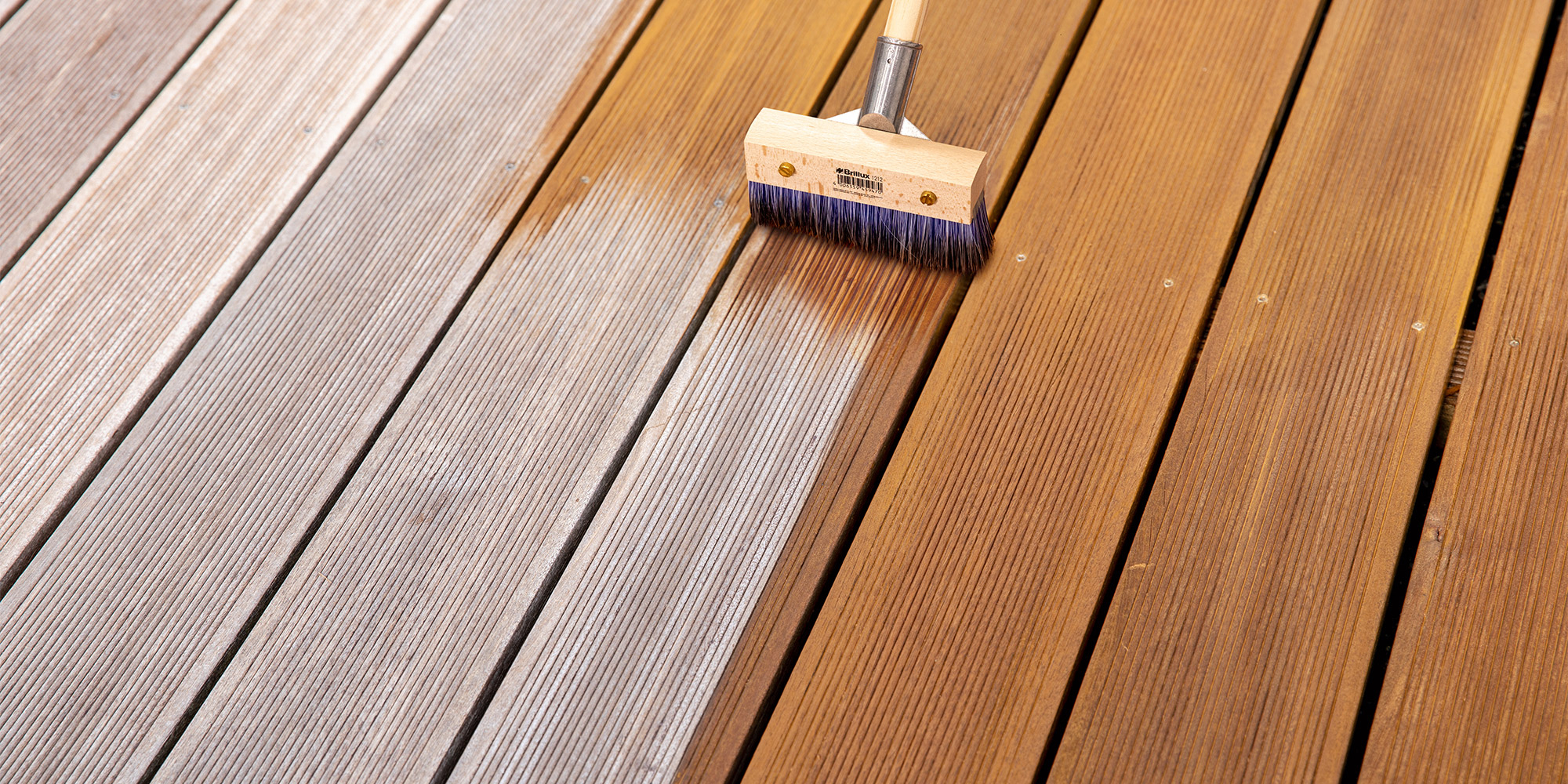 Holzterrasse mit Pflegebuerste als Beispiel fuer einen Untergrund im Aussenbereich