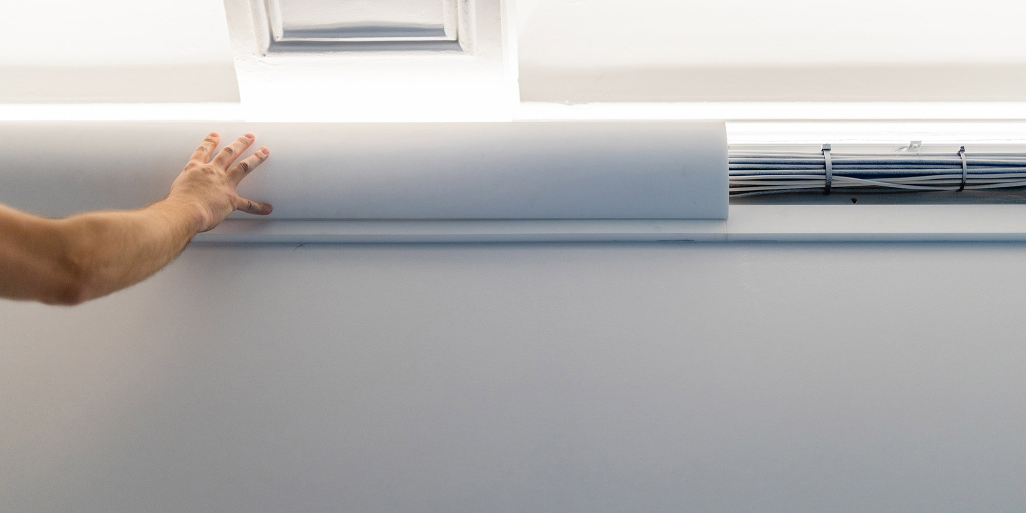 Mit dieser modernen Abdeckleiste von NMC können Kabel an der Decke im Wohnzimer einfach abgedeckt werden.