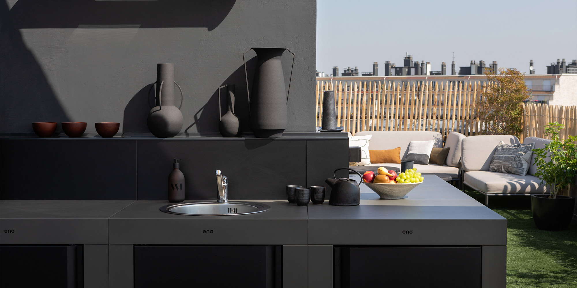 Moderne Dachterrasse mit dunkel gestrichener Außenwand, Outdoor Küche und Sitzbereich