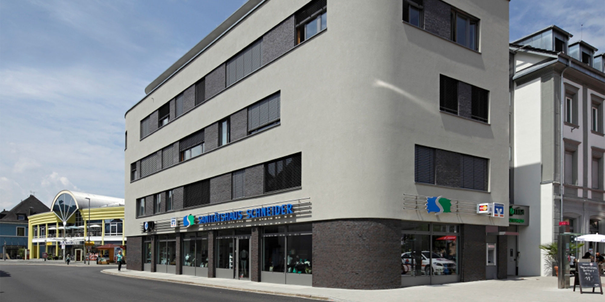 Detail einer hellen Fassade mit Fenstern. Gleichmaessige Oberflaeche