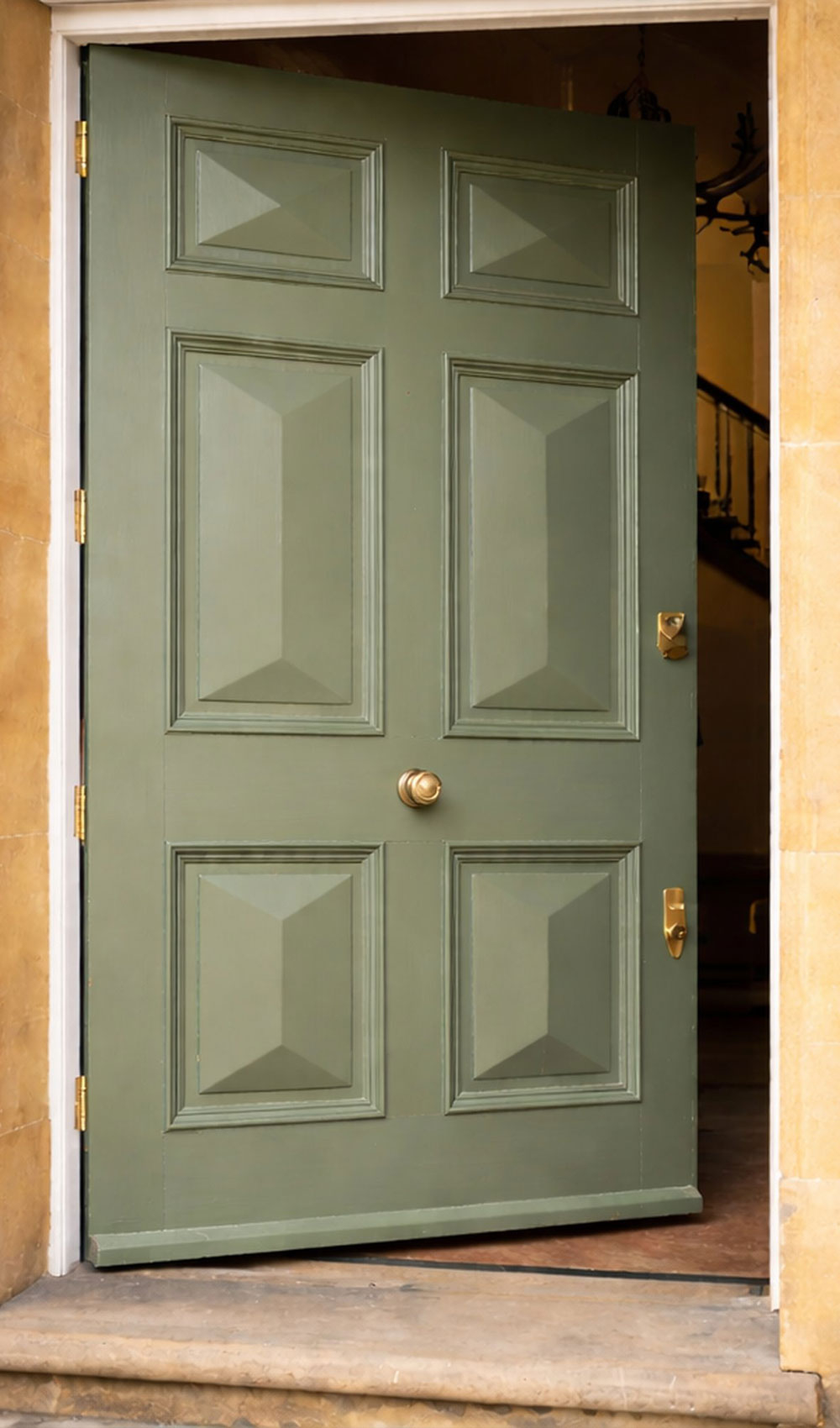 Geöffnete grüne Holzhaustür mit Kassetten im Steineingang - Ergebnis nach Holz Lackierung