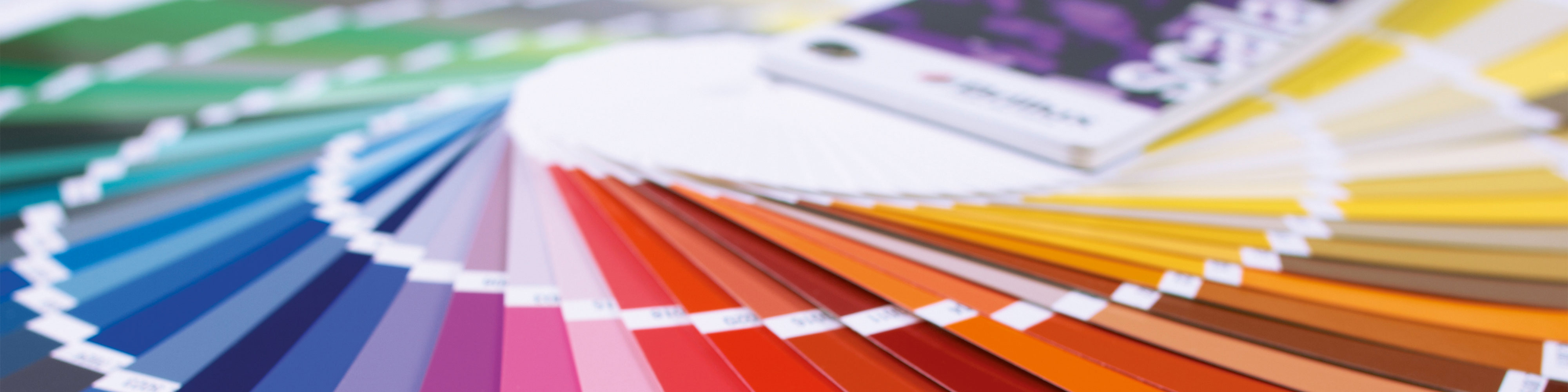 Aufgefächerte Farbtonkarten in vielen Farben als Headerbild für Wunschfarbton mischen