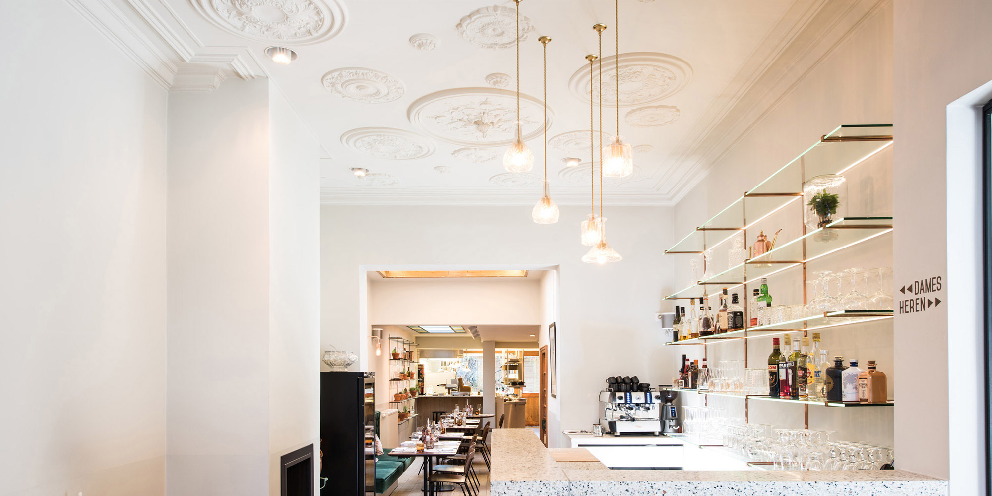 Verschieden große dekorative Rosetten für eine auffällige Deckengestaltung in einem modernen Cafe.