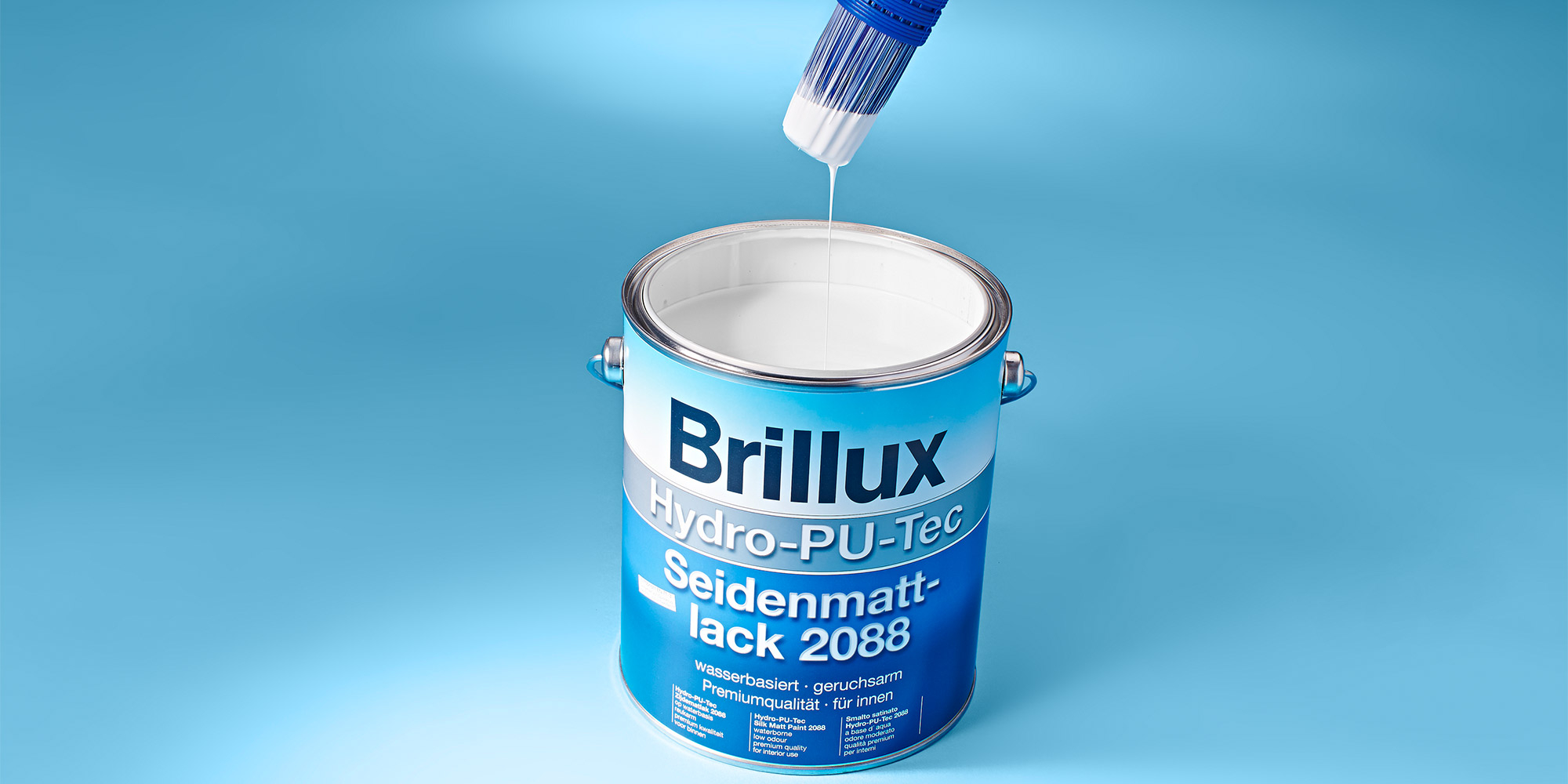 Pinsel mit weissem Lack ueber einer offenen Brillux Dose, Detailaufnahme der Lackanwendung