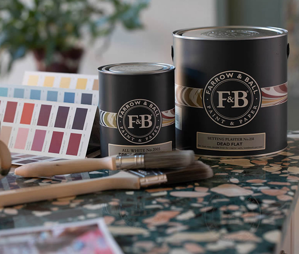 Farrow and Ball Farbdosen mit Farbkarten und Pinseln auf Tisch - Auswahl fuer Moebel streichen