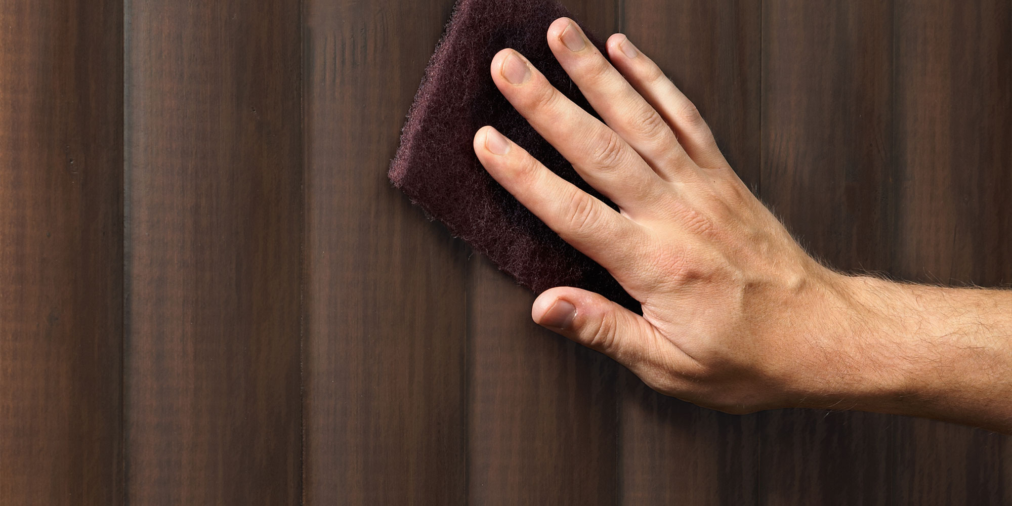 Hand bearbeitet dunkle Holzoberflaeche mit Schleifvlies, Vorbereitung vor dem Aufhellen und Lasieren