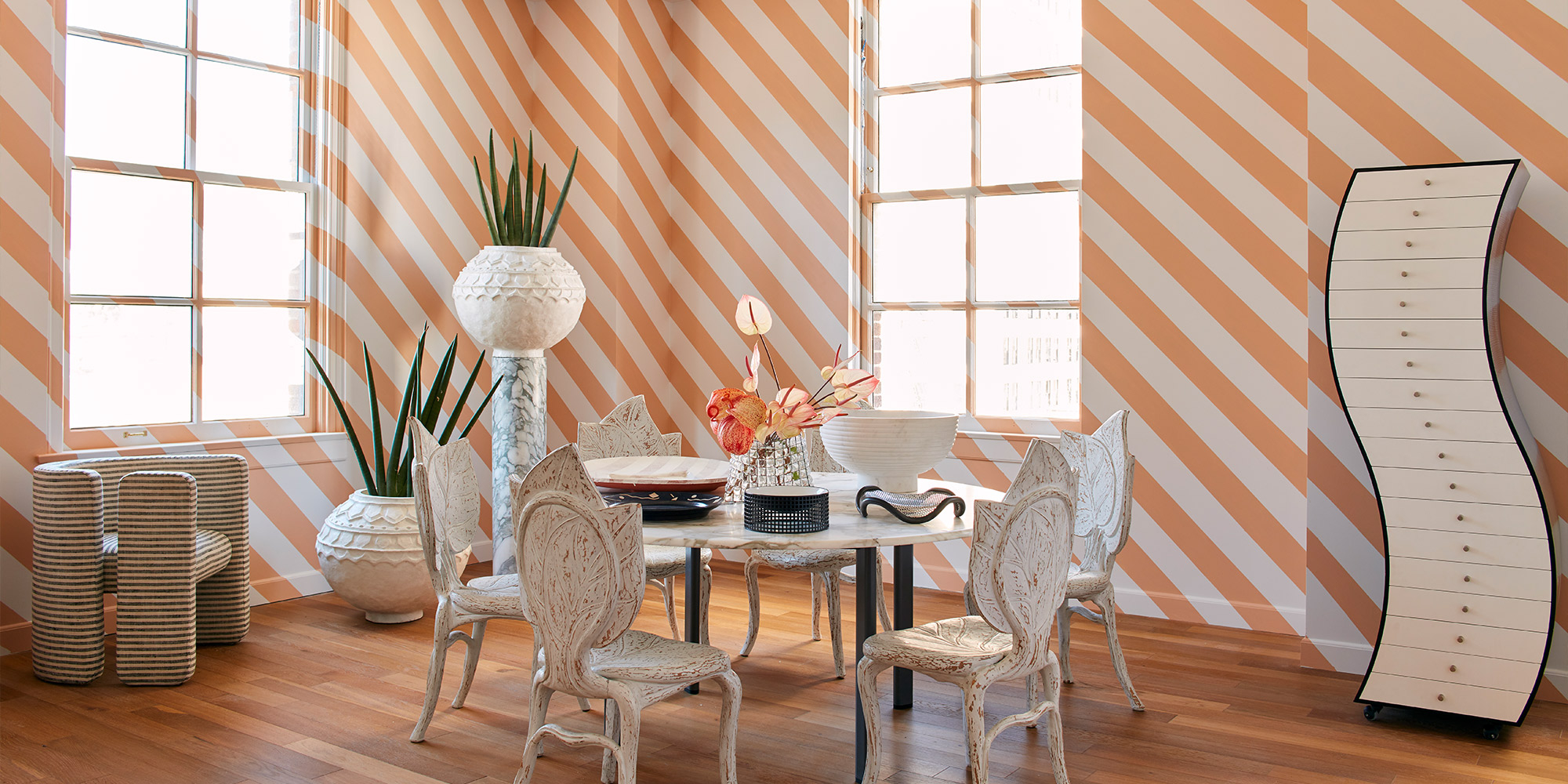 Raum mit diagonalen Streifen in Apricot und Weiß, Esstisch und Designmöbeln als Farbidee