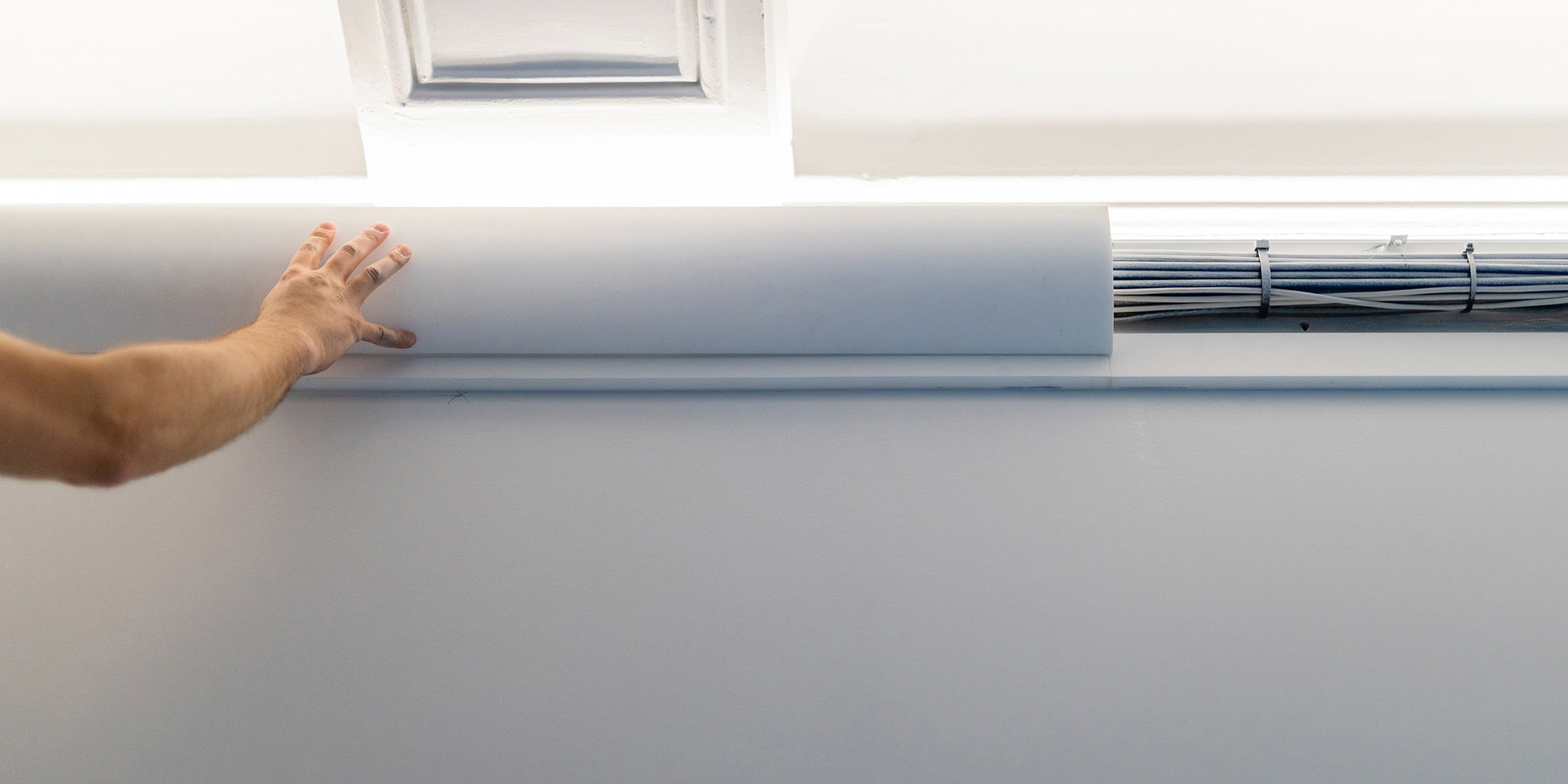 Im Hohlraum auf der Rückseite dieser weißen Abdeckleiste lassen sich Kabel verstecken.