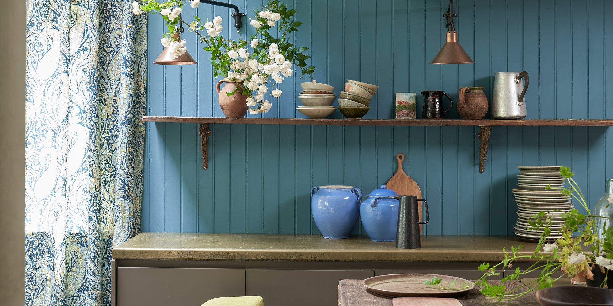 Blau gestrichene Holzvertäfelung mit Regal, Keramik und Küchenutensilien als Farbidee