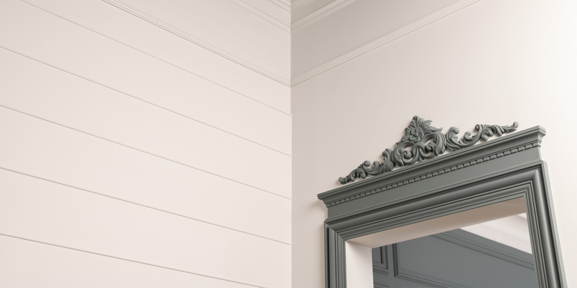 Ein barocker Türaufsatz aus Stuck als dekoratives Zierelement für einen modernen Wohnflur.