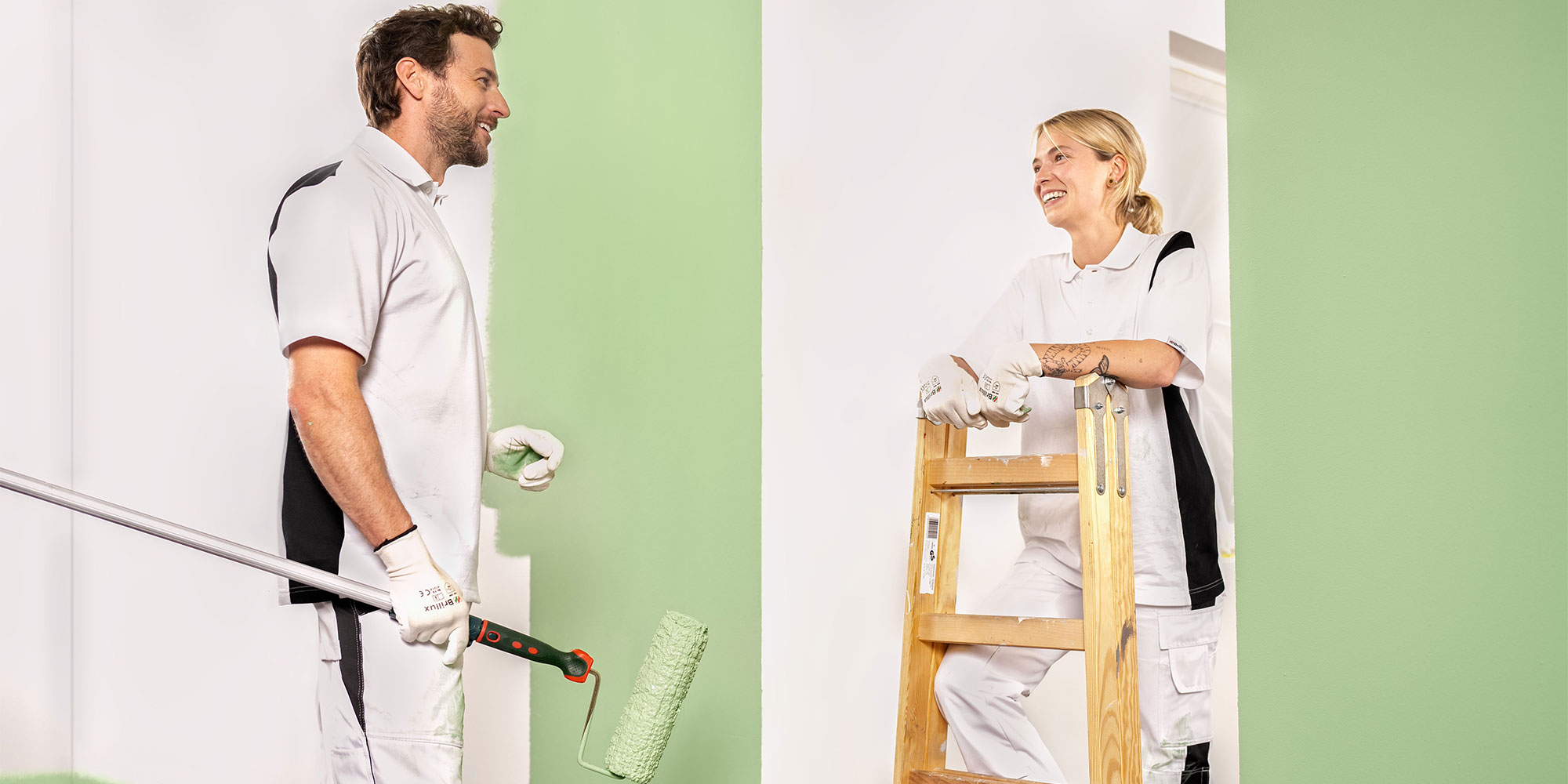 Person rollt gruene Wandfarbe auf - Beispiel fuer sauberen Auftrag und Abkleben in den FAQ